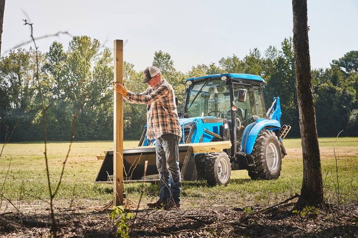man putting in fence posts