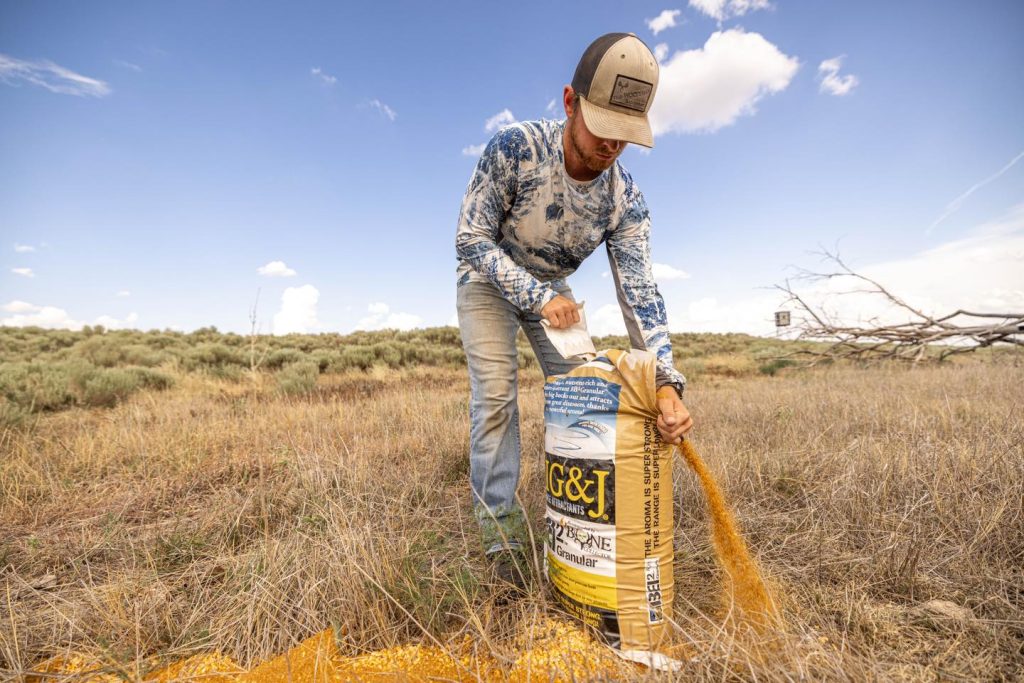 A man pours deer attractant on the ground
