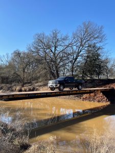 A truck crosses a bridge over a creek